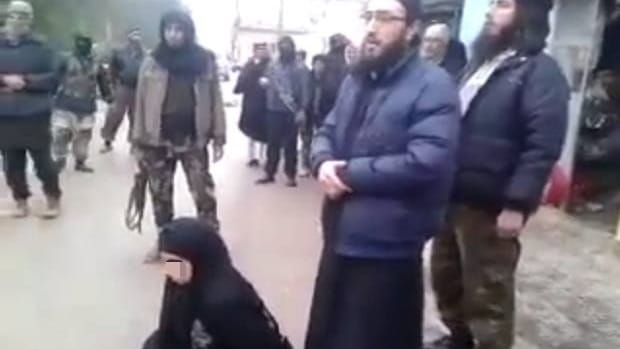 Standbild aus einem Video von 2015, das offenbar die Ermordung einer Frau unter der Aufsicht des jetzigen syrischen Justizministers Shadi Al-Waisi (M.) zeigt.