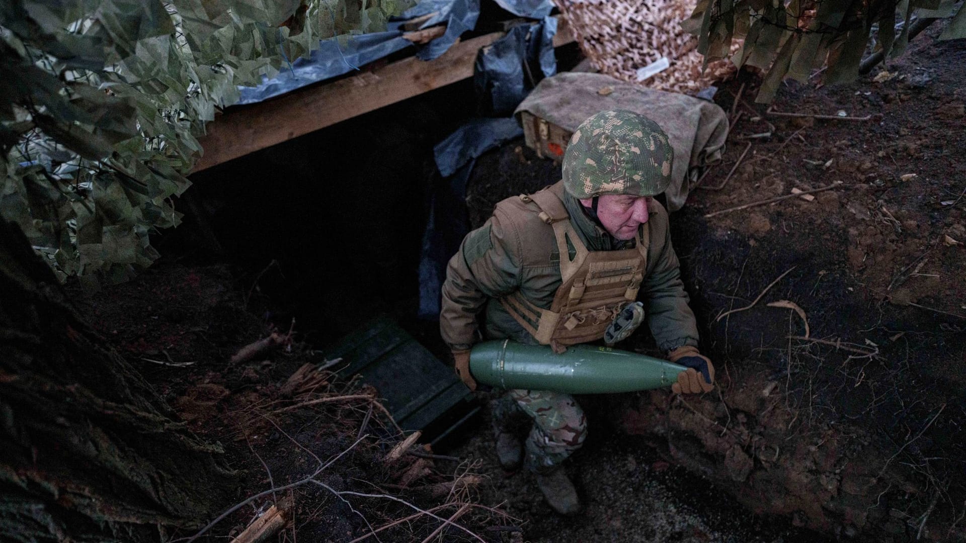 Ein ukrainischer Soldat der 14. Brigade der Nationalgarde "Tscherwona Kalyna" trägt eine Artilleriegranate, nahe Pokrowosk.