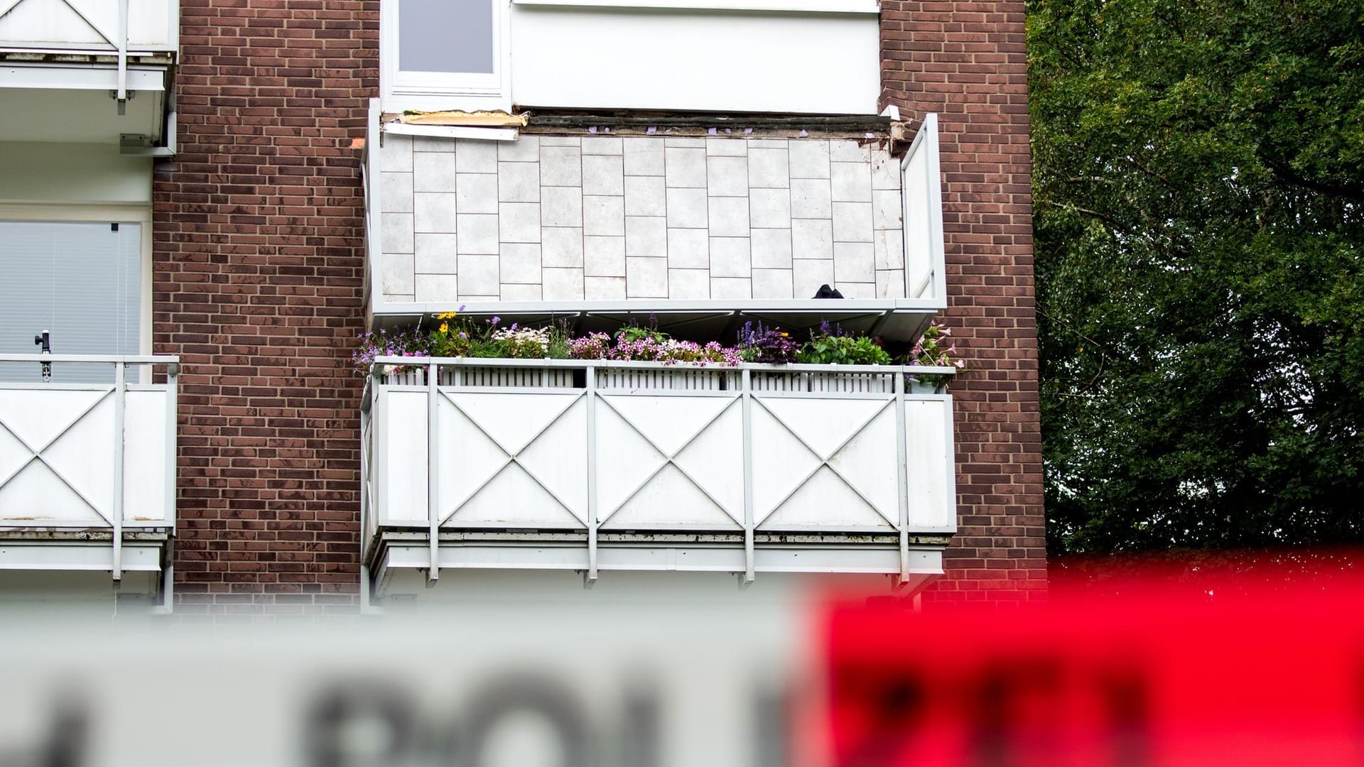 Ein abgestürzter Balkon hängt an einem Mehrfamilienhaus (Archivbild): Gegen vier Männer wird ermittelt.