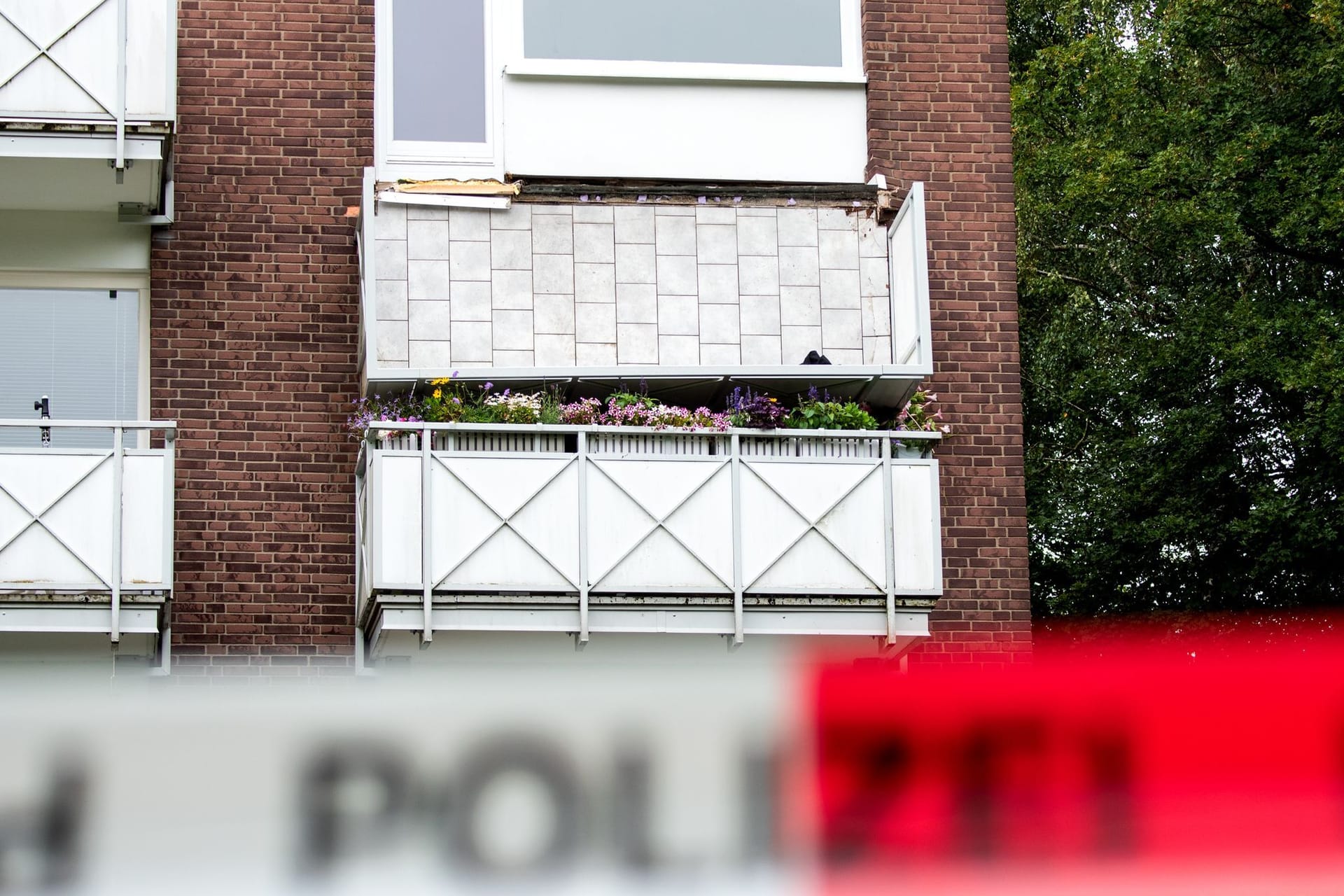 Ein abgestürzter Balkon hängt an einem Mehrfamilienhaus (Archivbild): Gegen vier Männer wird ermittelt.