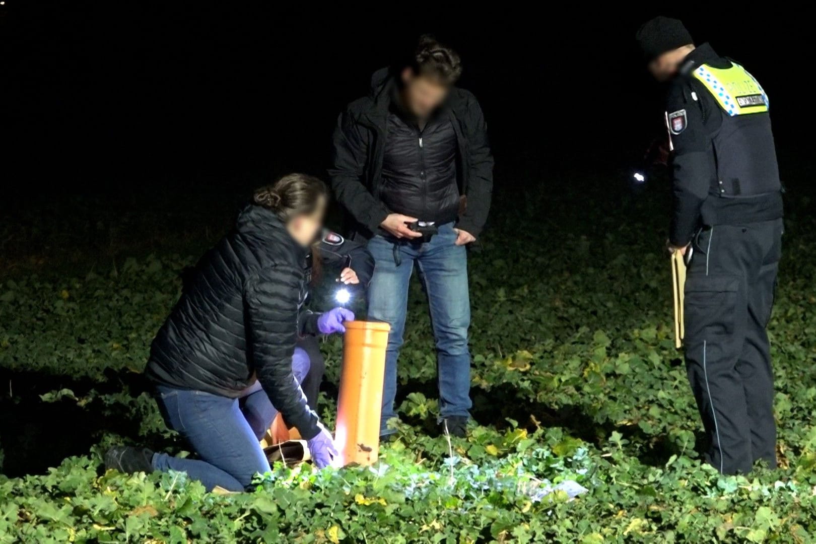 Spezialisten schauen sich die Überreste einer Kugelbombe auf einem Feld nördlich des Ochsenwerder Elbdeich an: Dort ist in der Silvesternacht ein junger Mann ums Leben gekommen.