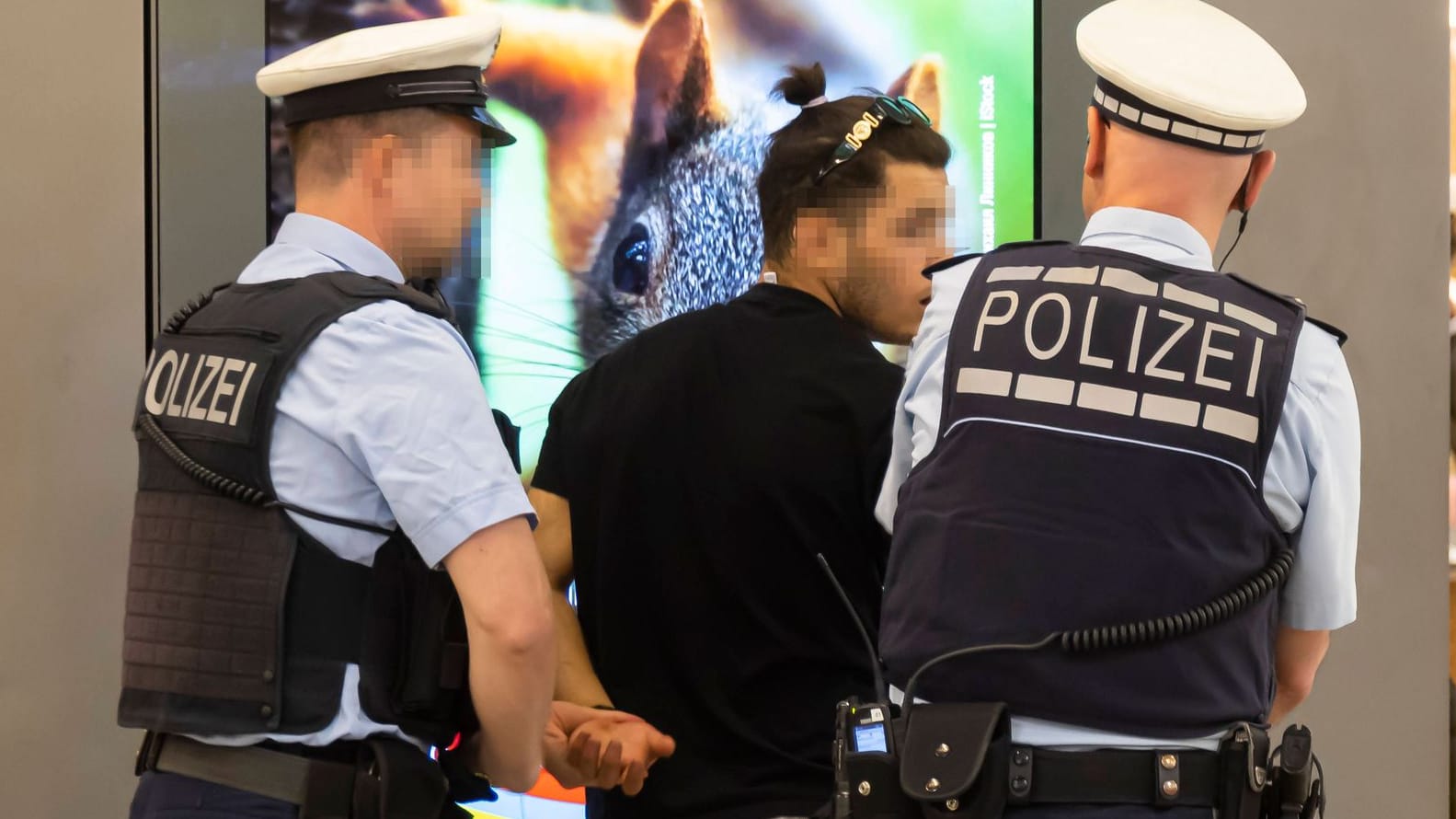 Zwei Polizisten kontrollieren einen Mann im Bahnhof. (Archivbild)