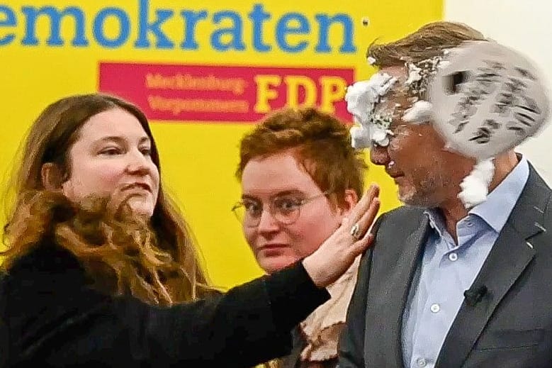 Eine Frau wirft Christian Lindner eine Seifentorte ins Gesicht.