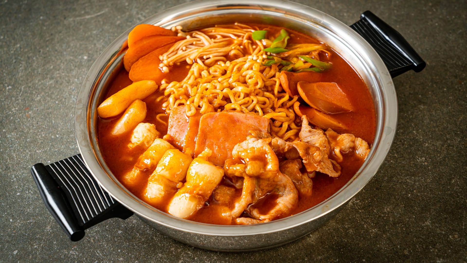 Budae Jjigae or Budaejjigae (Army stew or Army base stew). It is loaded with Kimchi, spam, sausages, ramen noodles and much more