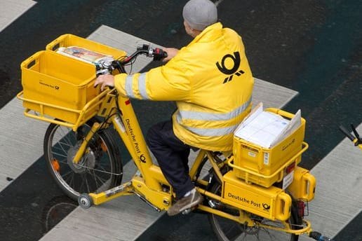 Ein Briefträger der Deutschen Post fährt mit einem Fahrrad (Symbolbild): Am Dienstag streiken Postboten bundesweit.