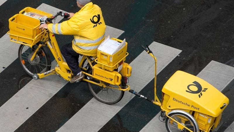 Ein Briefträger der Deutschen Post fährt mit einem Fahrrad (Symbolbild): Am Dienstag streiken Postboten bundesweit.