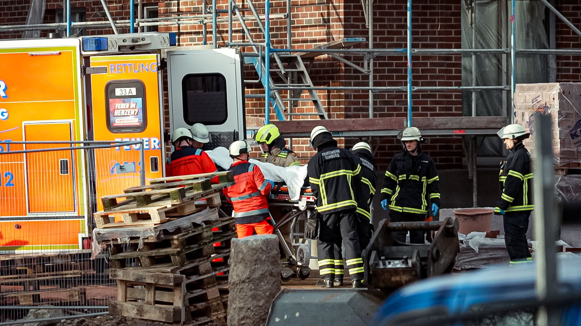 Rettungskräfte kümmern sich um den schwer verletzten Arbeiter: Was zu dem Unfall in Rothenburgsort geführt hat, ist unklar.