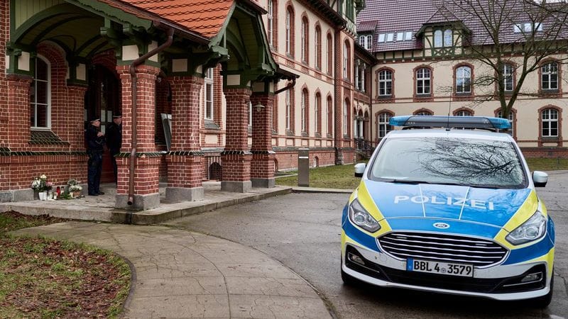 Ein Polizeifahrzeug steht vor einem Haus: In dem Gebäude hat es mehrere Gewaltverbrechen gegeben.