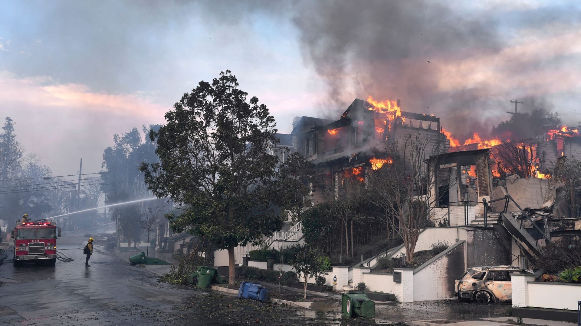 Feuerwehrleute kämpfen gegen die Flammen.