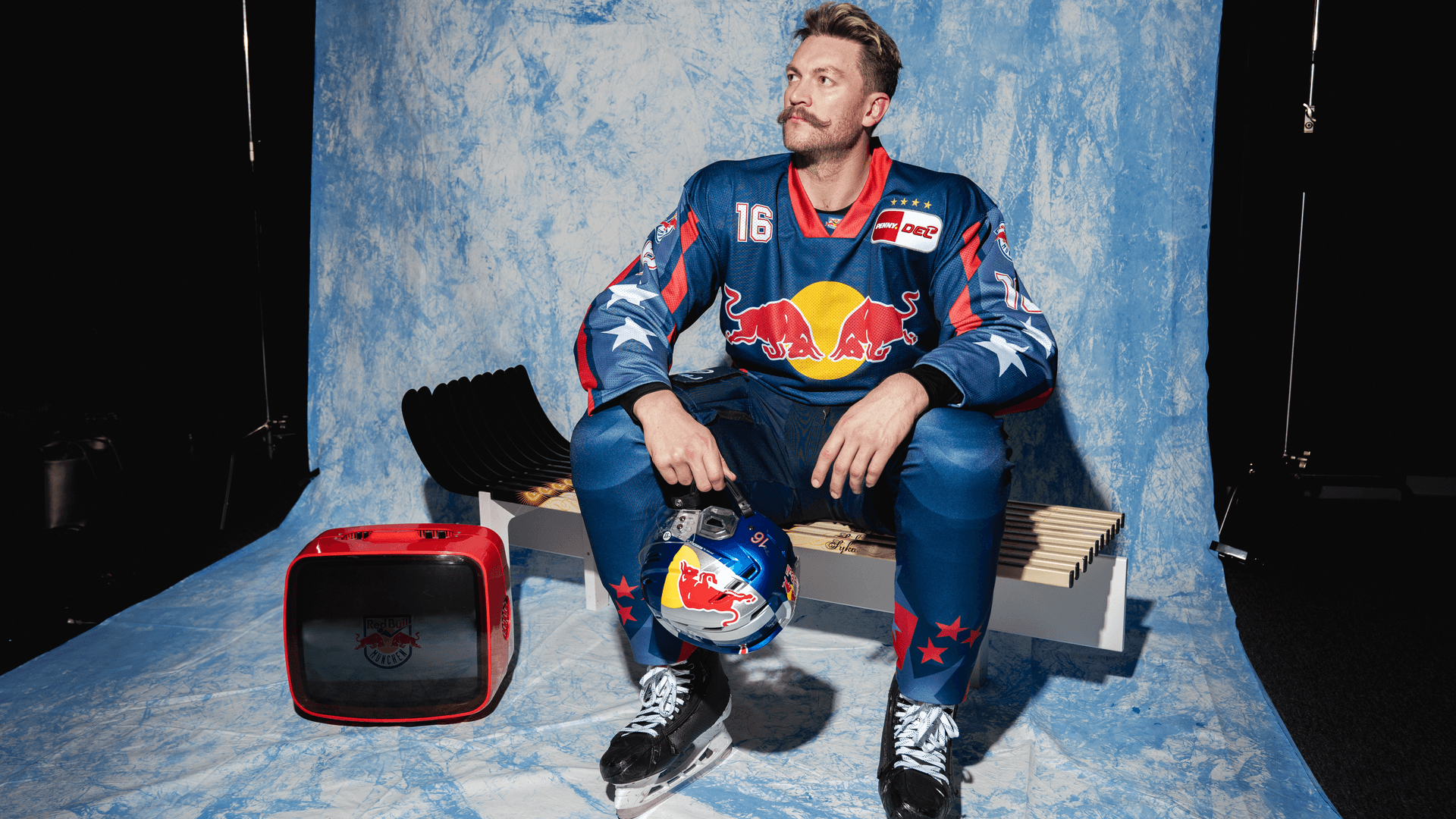 Konrad Abeltshauser präsentiert das Retro-Trikot des EHC Red Bull München: Für das Spiel gegen die DEG hat der Klub weitere Aktionen angekündigt.