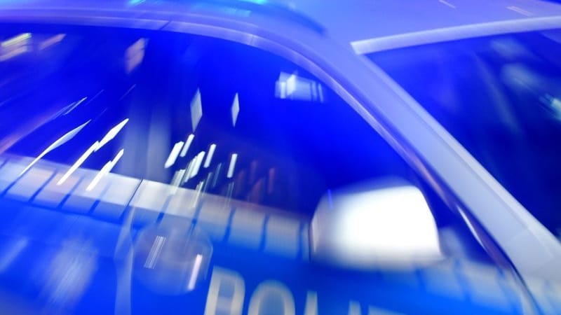 Ein Streifenwagen der Polizei steht mit eingeschaltetem Blaulicht auf der Straße.