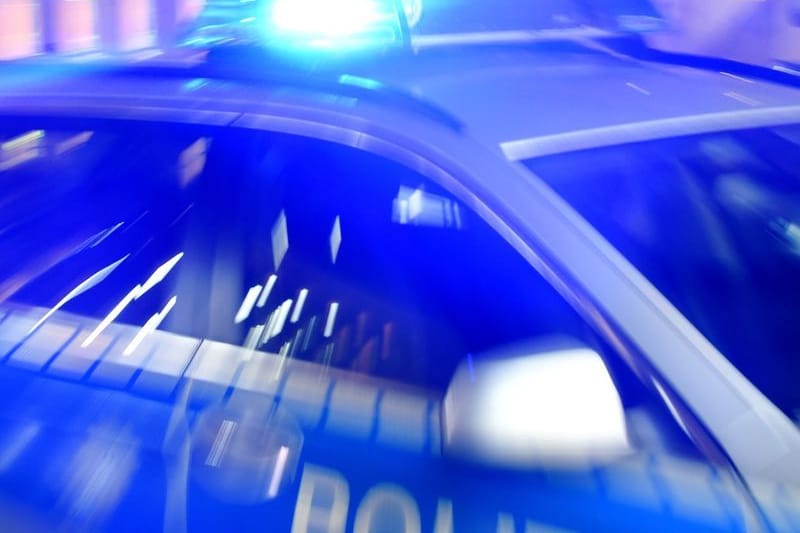 Ein Streifenwagen der Polizei steht mit eingeschaltetem Blaulicht auf der Straße.