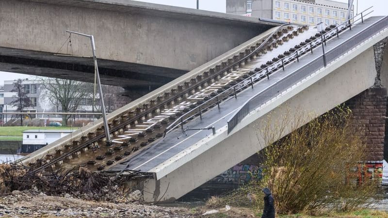 Eine Person geht am Elbufer auf der Neustädter Seite auf dem Abrissfeld der teileingestürzten Carolabrücke entlang.