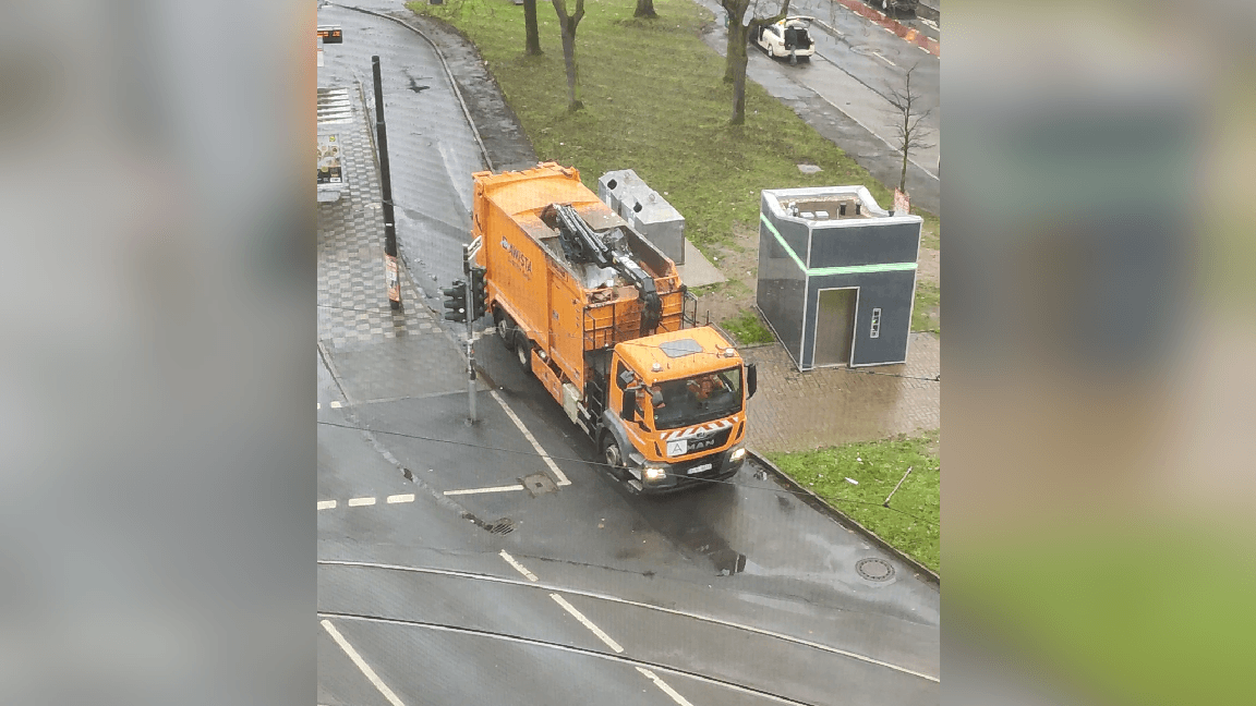 Mitarbeiter der Awista fahren nach getaner Arbeit ab (Screenshot): Neben dem Müllwagen befindet sich eine öffentliche Toilette.