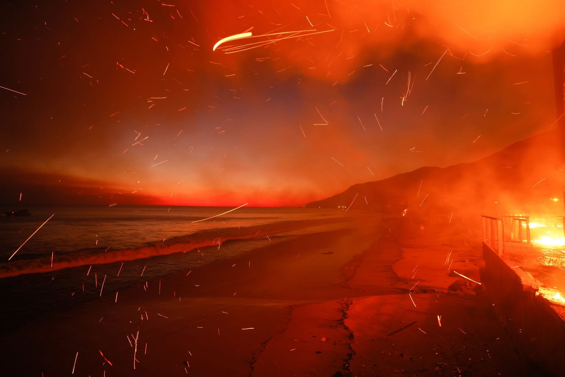 USA, Malibu: Das Palisades-Feuer brennt auf einem Grundstück am Strand.