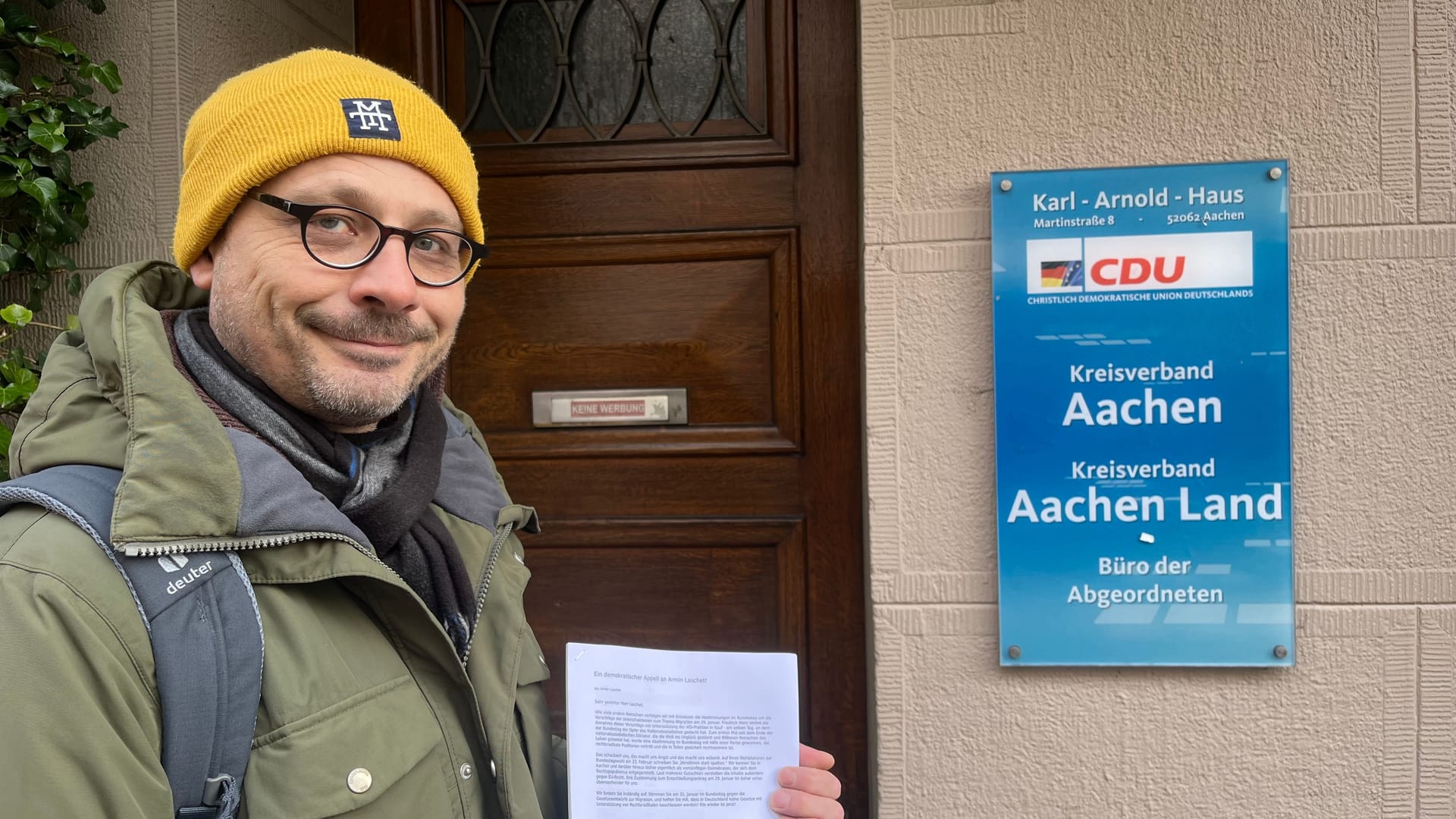 David Kraft wirft eine Liste mit rund 1.400 Unterschriften in den Briefkasten des Wahlbüros von Armin Laschet.