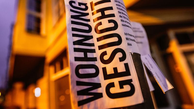 Ein Schild mit der Aufschrift "Wohnung gesucht" hängt an einer Laterne: Die Mieten werden in NRW künftig in 57 Kommunen begrenzt.