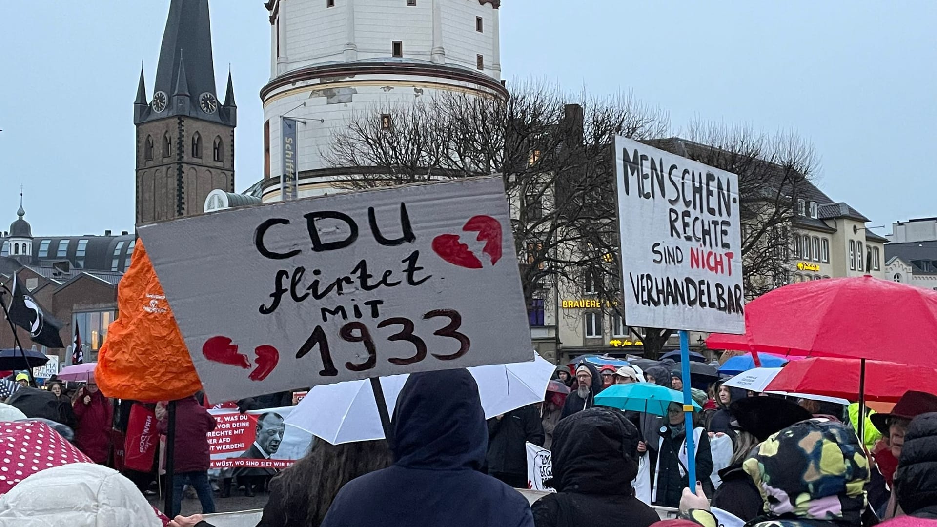 Mehrere Plakate kritisieren die CDU für ihre Zusammenarbeit mit der AfD im Bundestag.