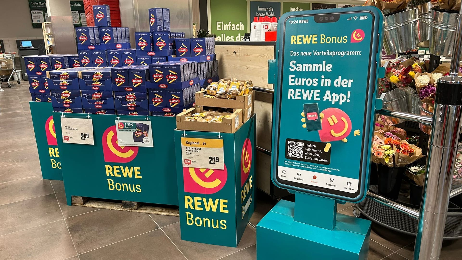 Aufsteller und Angebote: So bewirbt Rewe derzeit in den Filialen sein neues Kundenbindungsprogramm.