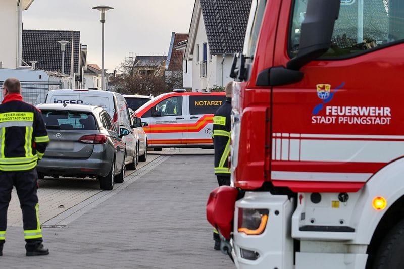 Ein Krankenwagen und ein Fahrzeug der Feuerwehr stehen in einer Wohnsiedlung mit Einfamilienhäusern nahe einer Unfallstelle: Hier kam es zum tödlichen Unfall.