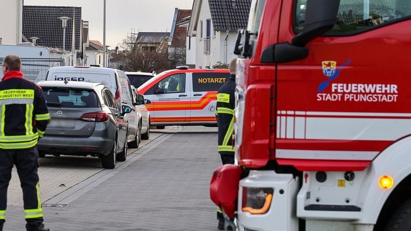 Ein Krankenwagen und ein Fahrzeug der Feuerwehr stehen in einer Wohnsiedlung mit Einfamilienhäusern nahe einer Unfallstelle: Hier kam es zum tödlichen Unfall.