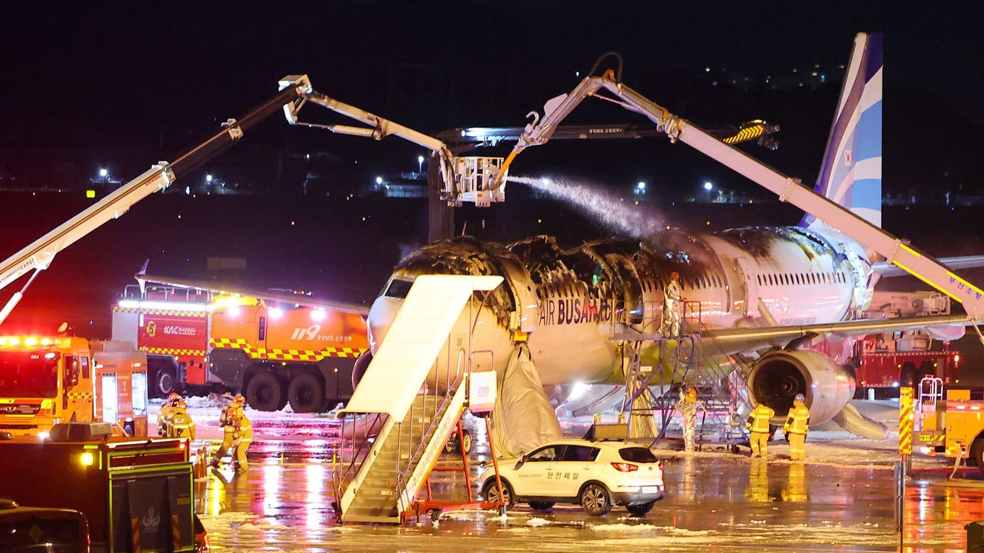 Feuerwehrleute löschen den Brand am Flugzeug: Alle Passagiere kamen mit dem Schrecken davon.