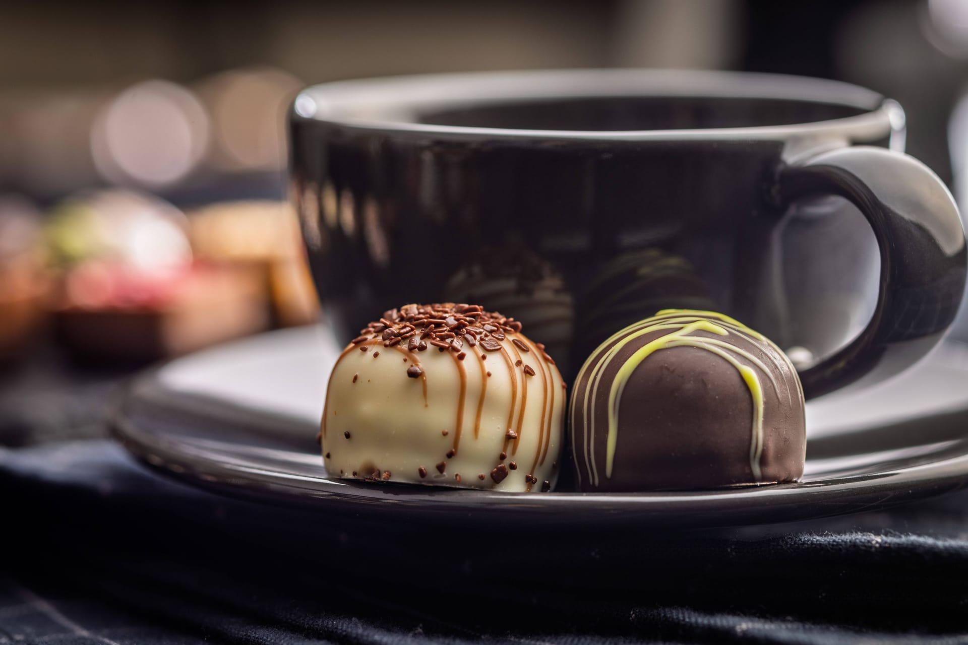 Eine Tasse Kaffee und zwei Pralinen (Symbolbild): Die Kombination macht ganz schön munter.