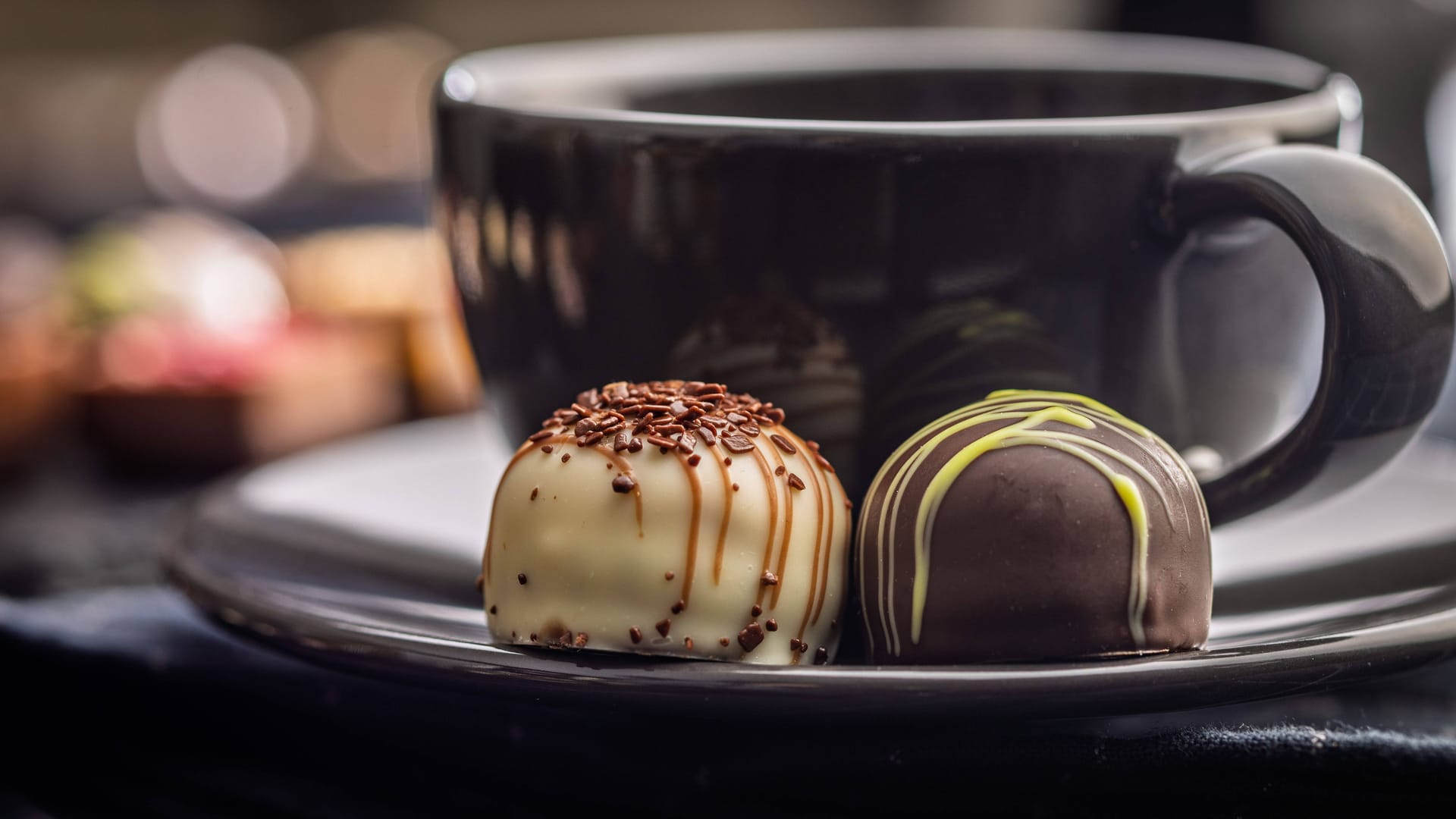 Eine Tasse Kaffee und zwei Pralinen (Symbolbild): Die Kombination macht ganz schön munter.