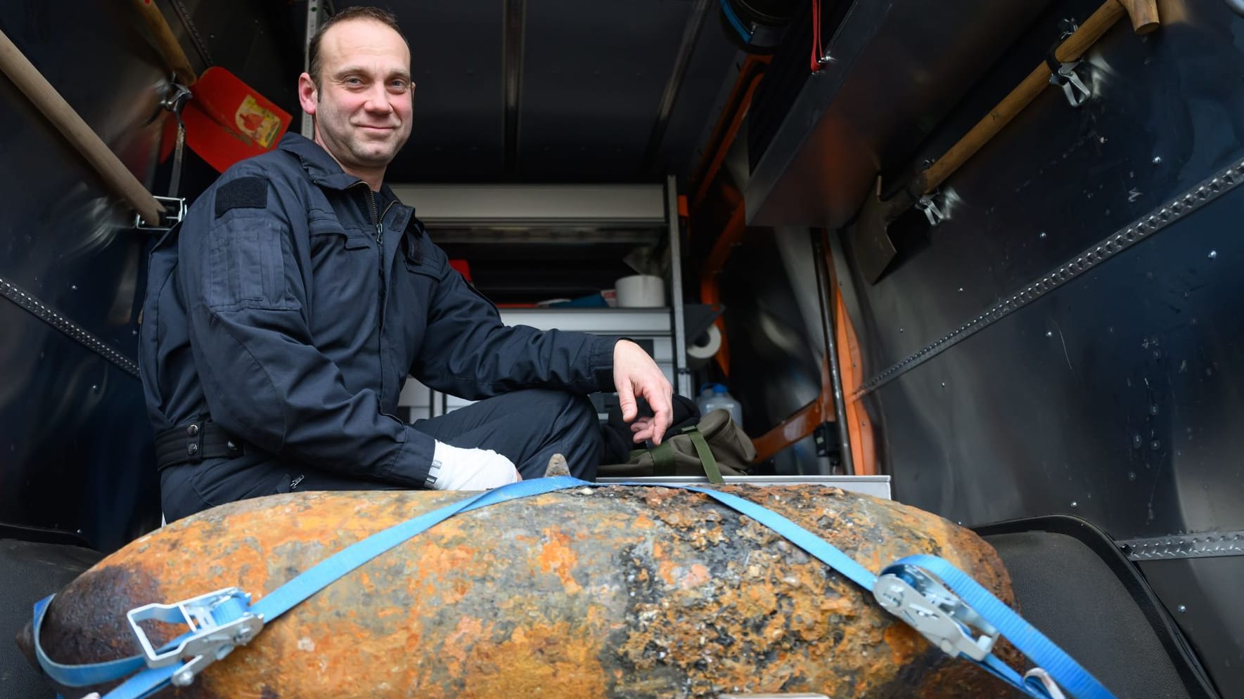 Sprengmeister Thomas Zowalla von der Kampfmittelbeseitigung (KMBD) hockt nach der Entschärfung einer Weltkriegsbombe, die an der Baustraße für den Abriss der Carolabrücke gefunden worden war, hinter dem Sprengkörper.