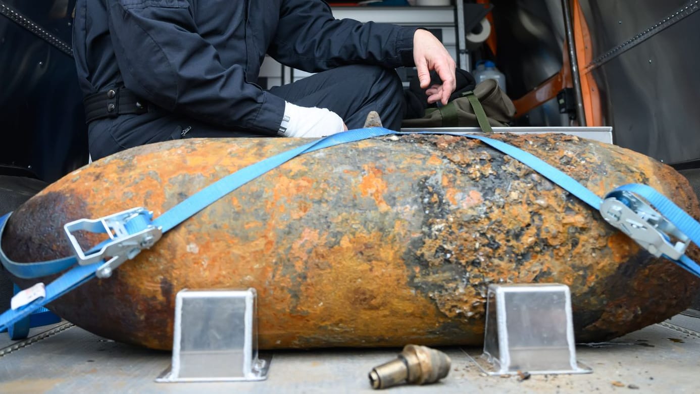 Sprengmeister Thomas Zowalla von der Kampfmittelbeseitigung (KMBD) hockt nach der Entschärfung einer Weltkriegsbombe, die an der Baustraße für den Abriss der Carolabrücke gefunden worden war, hinter dem Sprengkörper.