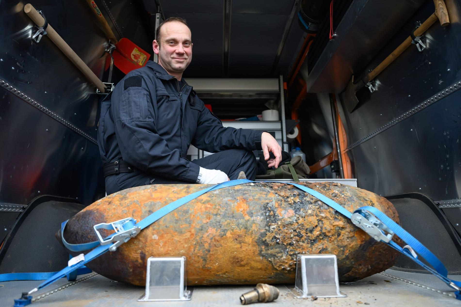 Sprengmeister Thomas Zowalla von der Kampfmittelbeseitigung (KMBD) hockt nach der Entschärfung einer Weltkriegsbombe, die an der Baustraße für den Abriss der Carolabrücke gefunden worden war, hinter dem Sprengkörper.