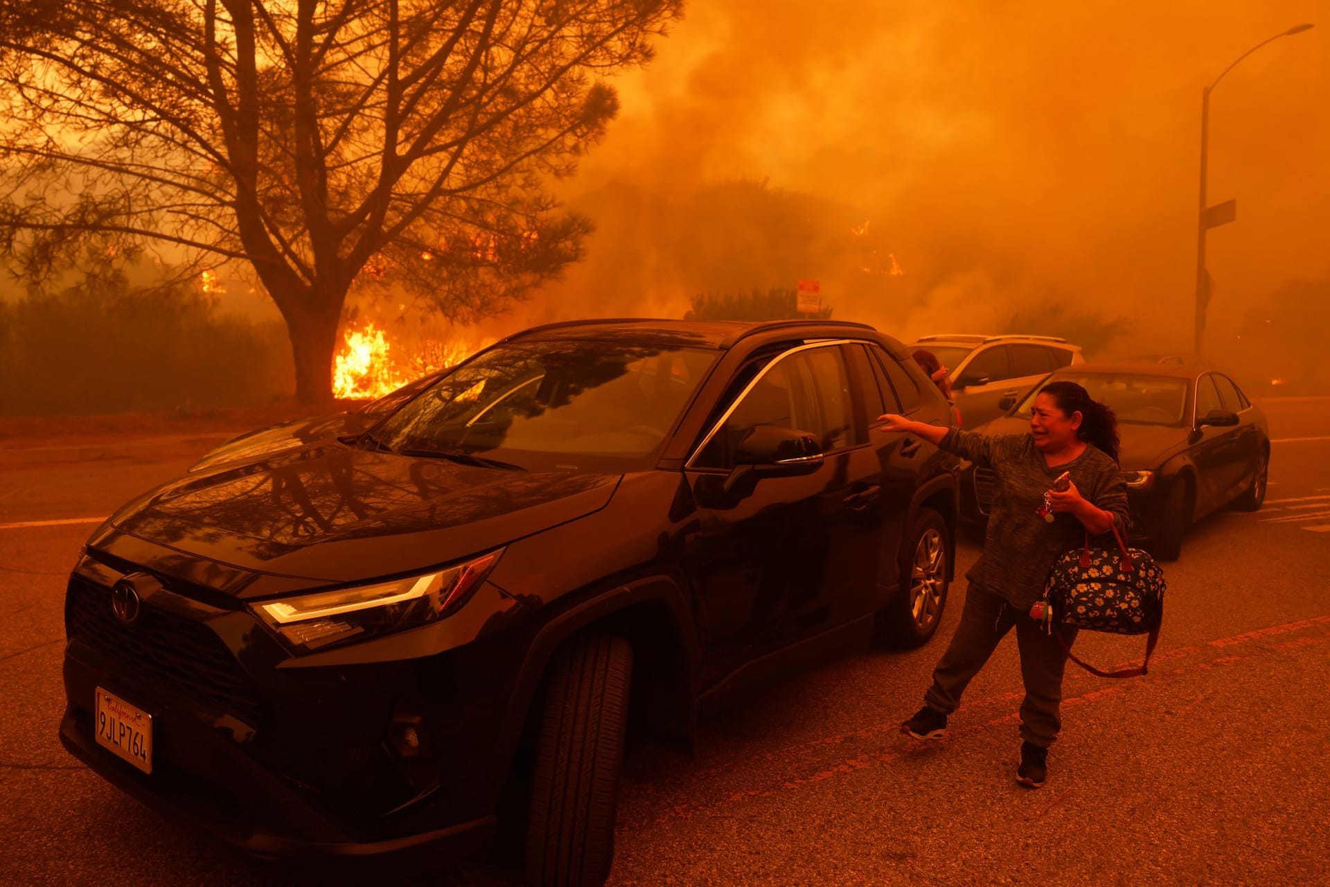 Eine Frau weint, als das Palisades-Feuer im Stadtteil Pacific Palisades von Los Angeles ausbricht.