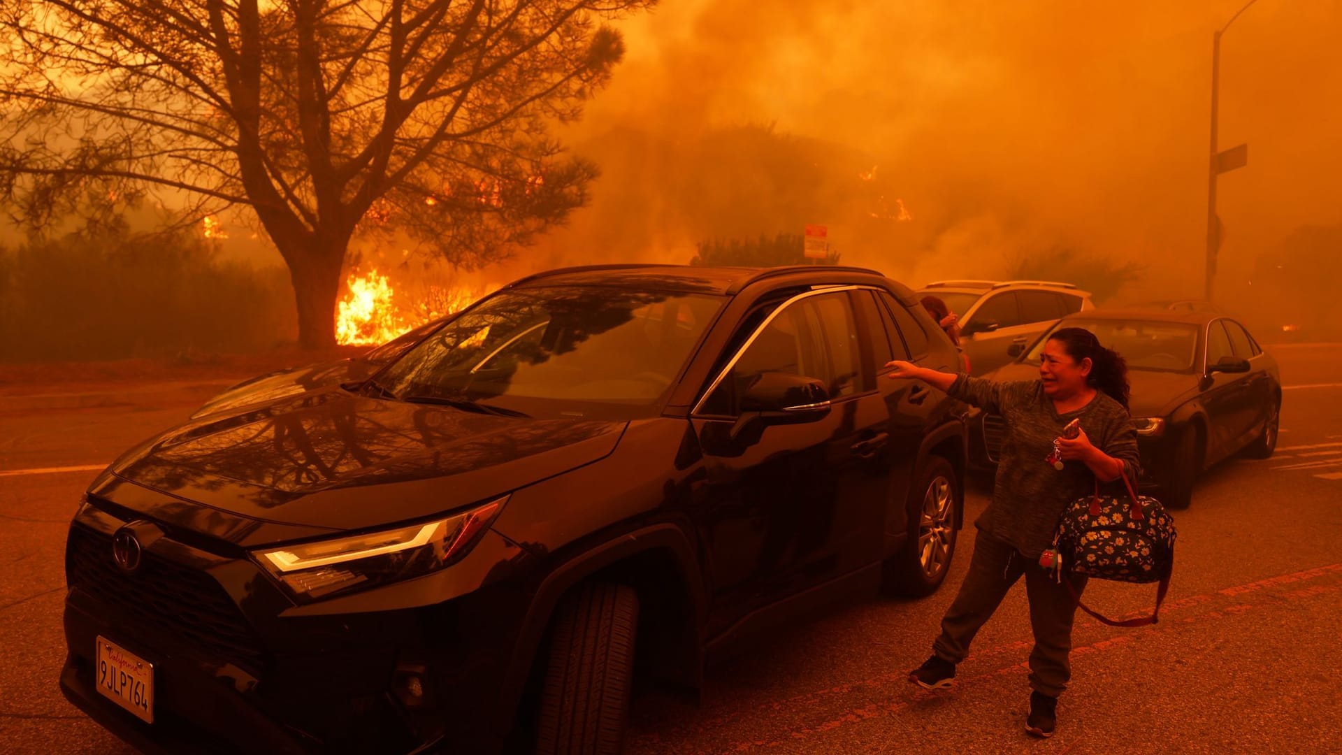 Eine Frau weint, als das Palisades-Feuer im Stadtteil Pacific Palisades von Los Angeles ausbricht.