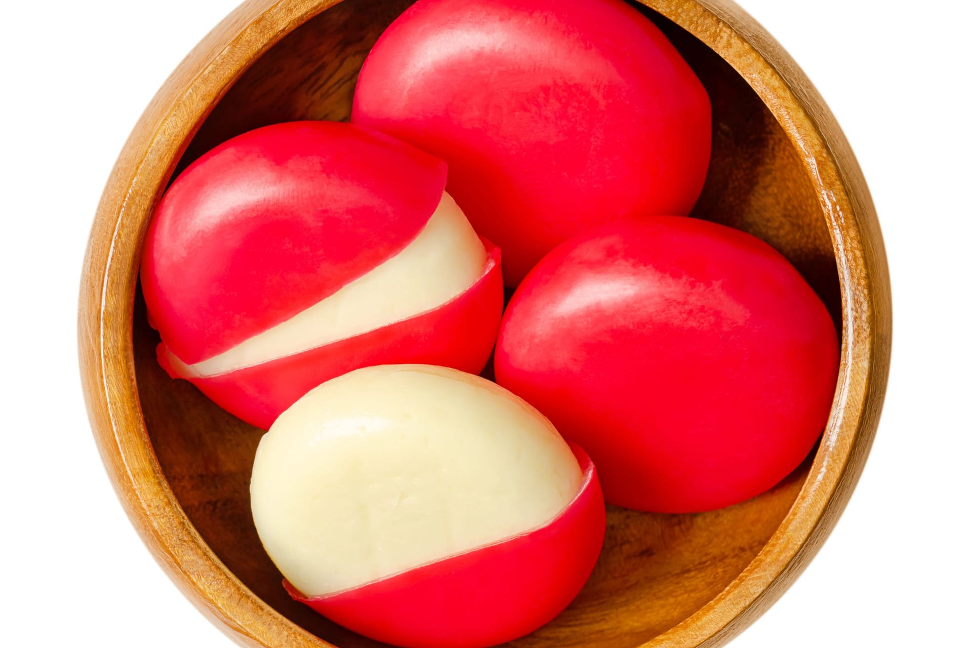 Snack cheese disks in red wax encasements in a wooden bowl