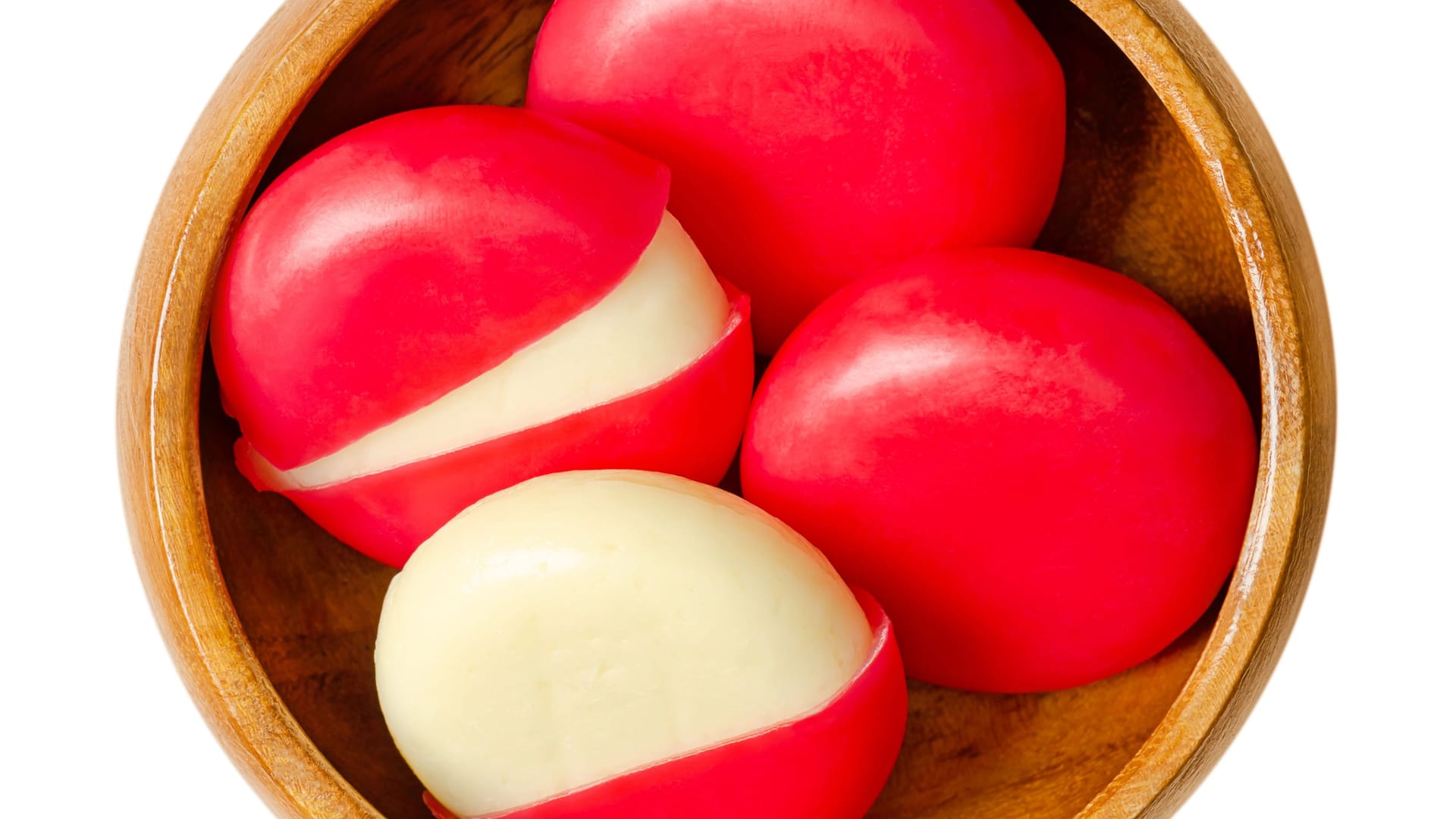 Snack cheese disks in red wax encasements in a wooden bowl