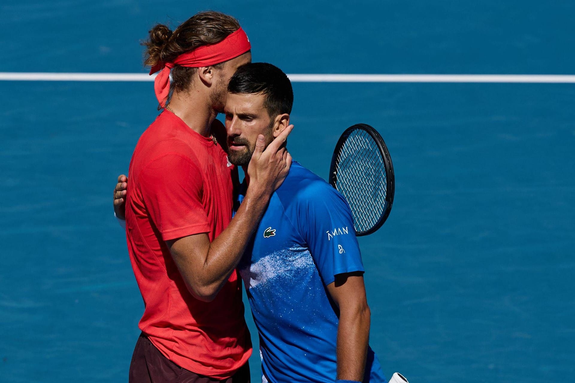 Alexander Zverev (l.) spricht nach dem Match mit Novak Djokovic.