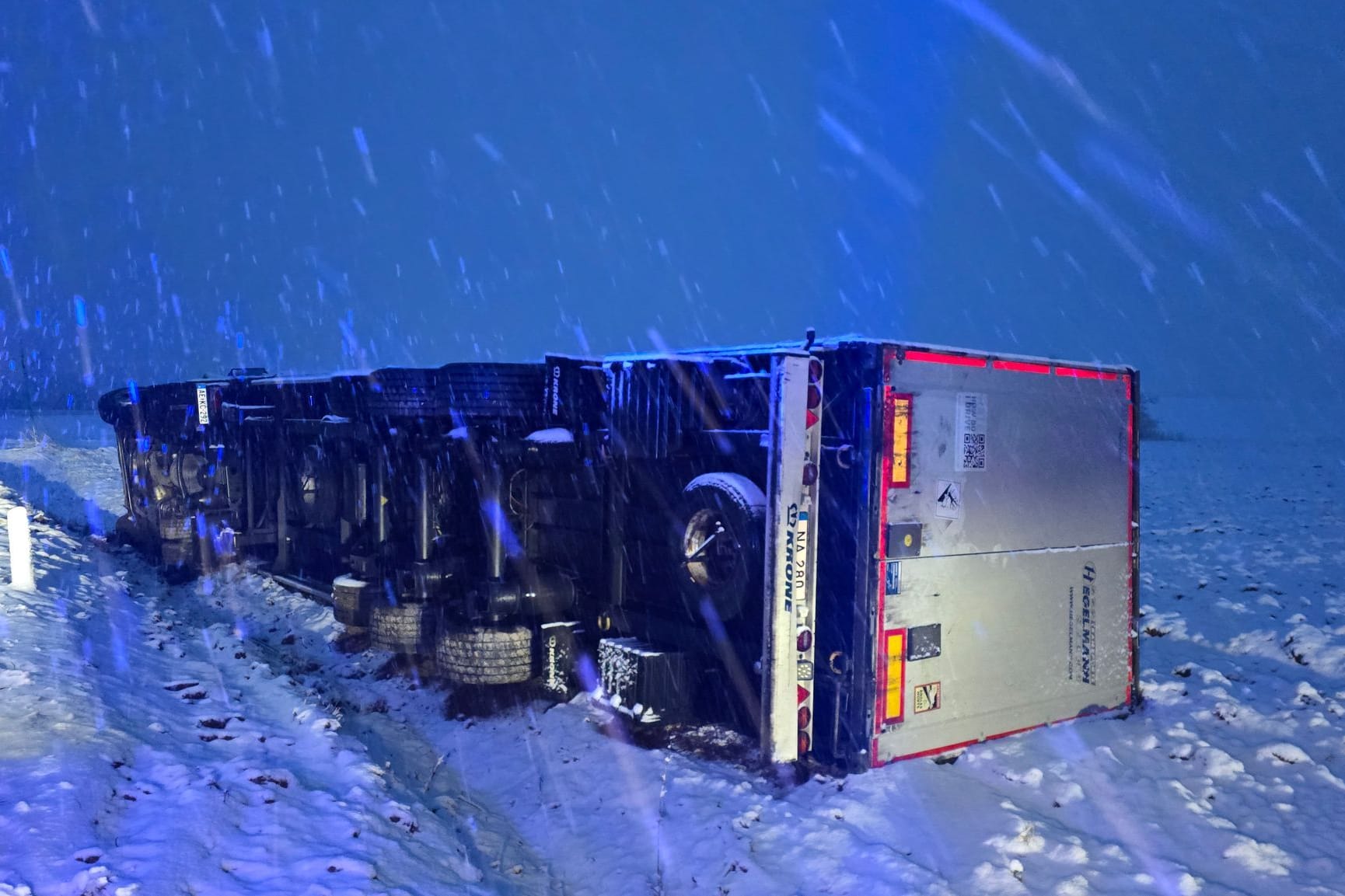 Ein Lastwagen liegt umgekippt neben der Straße. Auf der Landstraße 159 zwischen Wederath und Hinzerath im Hunsrück hat der starke Schneefall zu einem schweren Verkehrsunfall geführt.