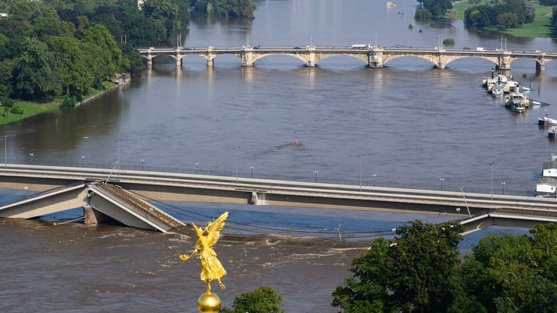 Die Hochwasser führende Elbe fließt an der zum Teil eingestürzten Carolabrücke entlang, im Vordergrund ist der Engel «Fama» auf der Kunstakademie zu sehen. (zu dpa: «Bürger verlangen Behelfsbrücke für Dresdner Elbquerung»)