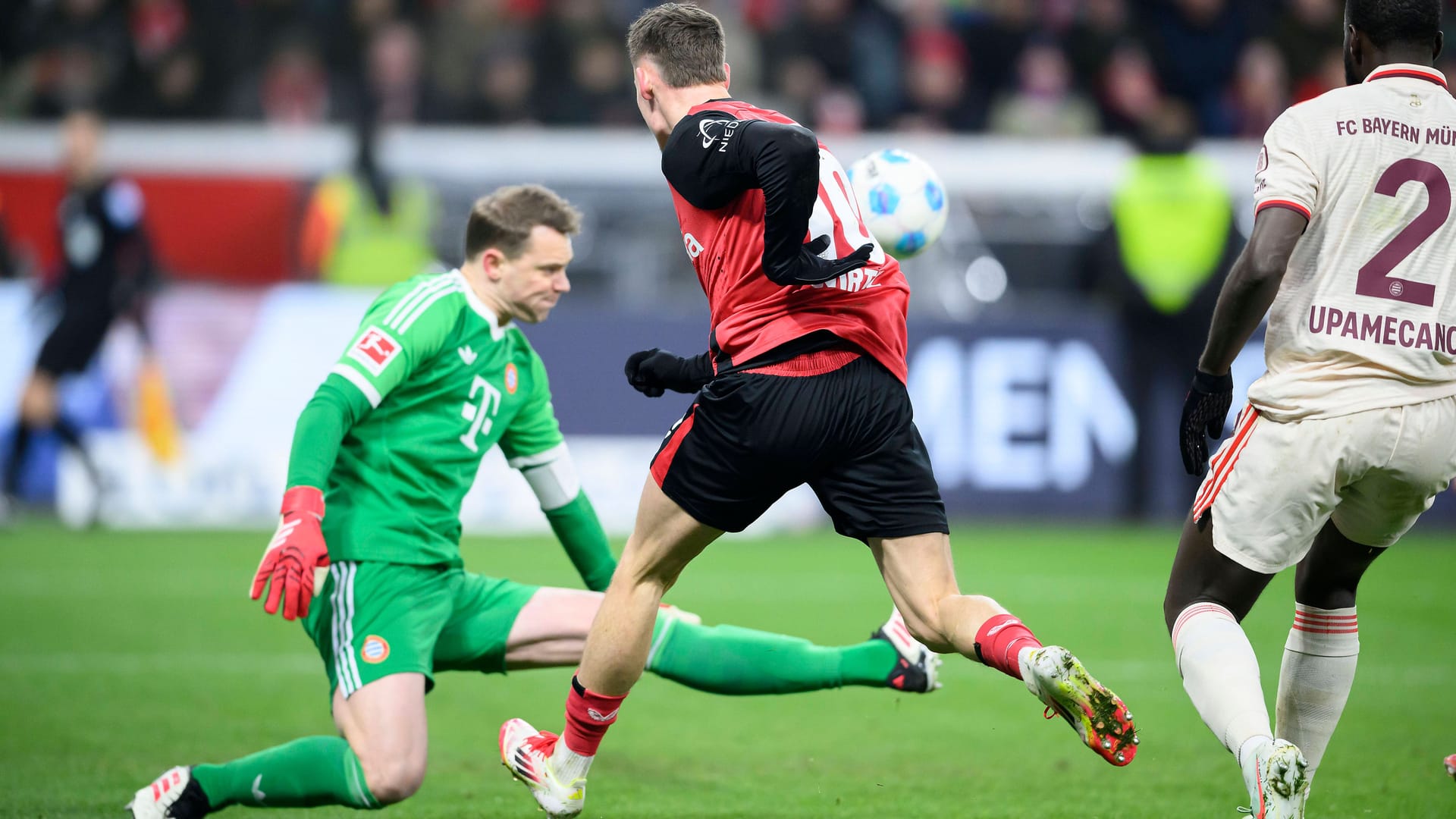 Schwerstarbeit: Bayerns Manuel Neuer (li.) klärt gegen Leverkusens Florian Wirtz.