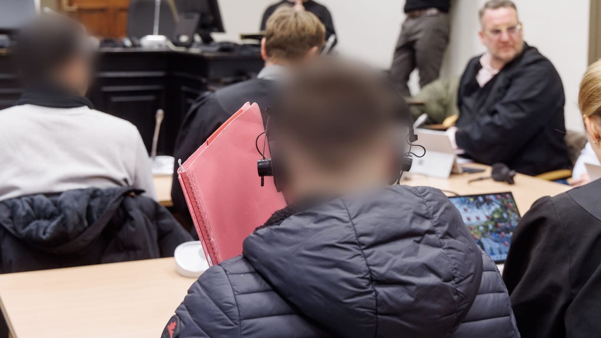 Angeklagte sitzen zu Prozessbeginn im Gerichtssaal. Ihnen wird Geldwäsche vorgeworfen.