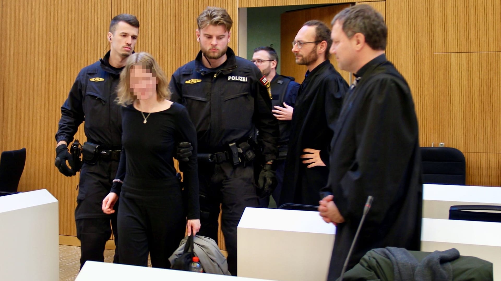 Die Angeklagte Hanna S. wird am Mittwoch in den Gerichtssaal geführt: Neben ihr stehen ihre Anwälte Yunus Ziyal (mit Brille) und Peer Stolle (r.).