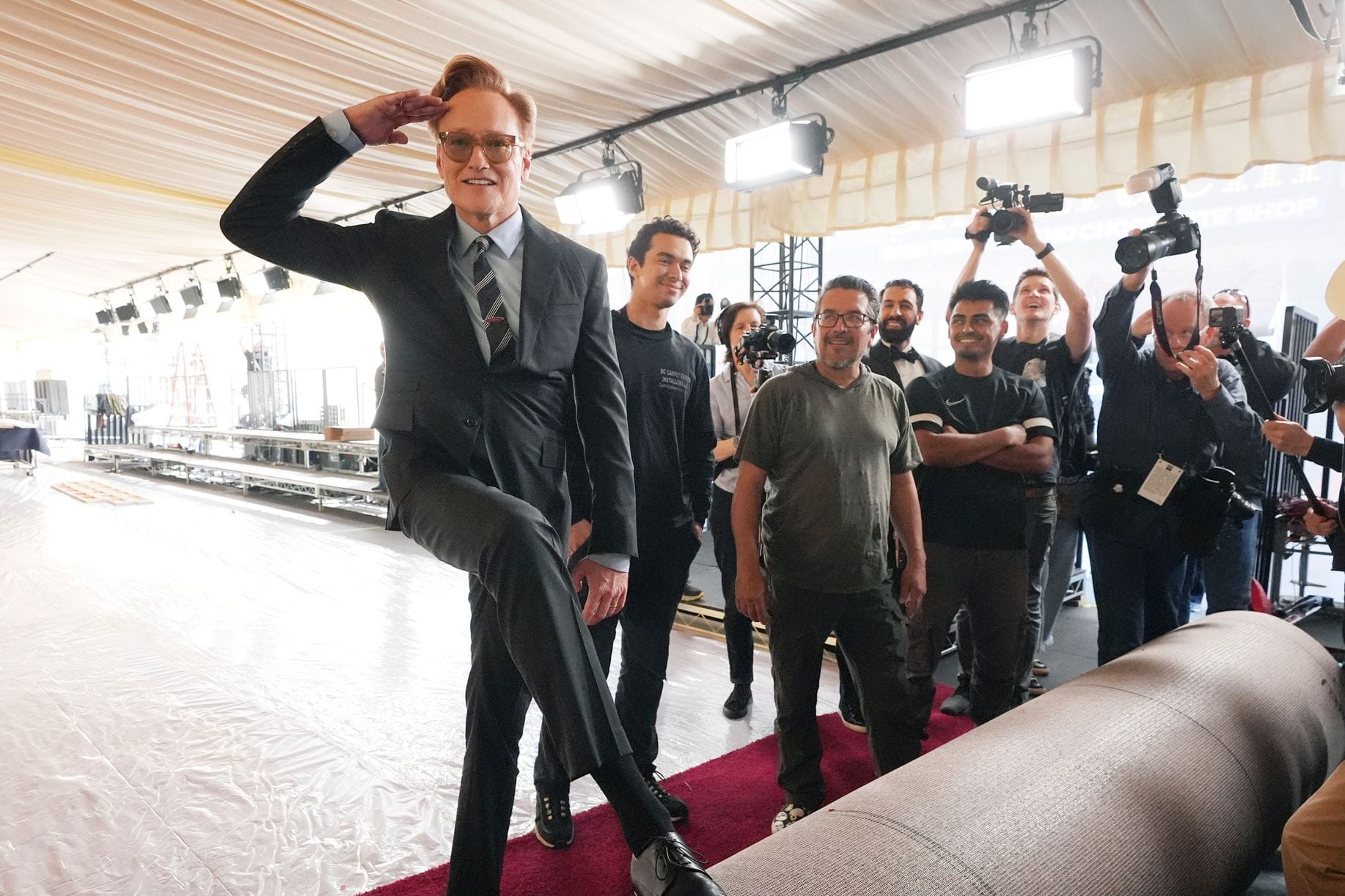 Beim Ausrollen des roten Teppichs macht Oscar-Moderator Conan O'Brien schon die erwartet schräge Figur.