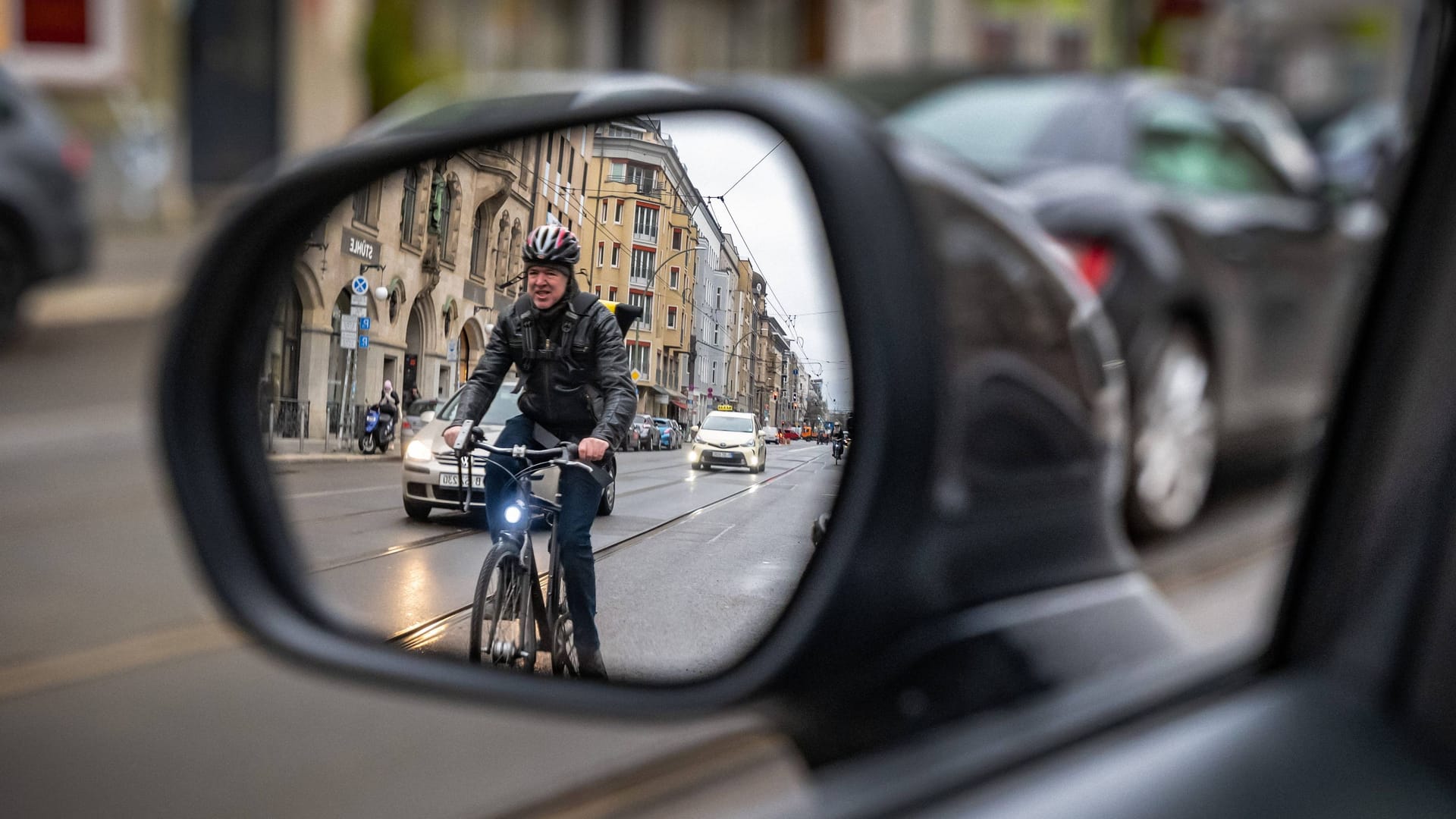 Radfahrer von hinten: Wer die Fahrertür mit der rechten Hand öffnet, macht automatisch einen Schulterblick.