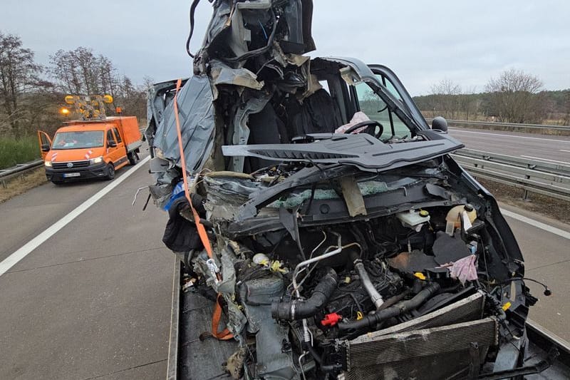 Ein Autowrack steht auf einem Abschleppwagen: In dem Transporter saßen der Verletzte und die beiden Toten.