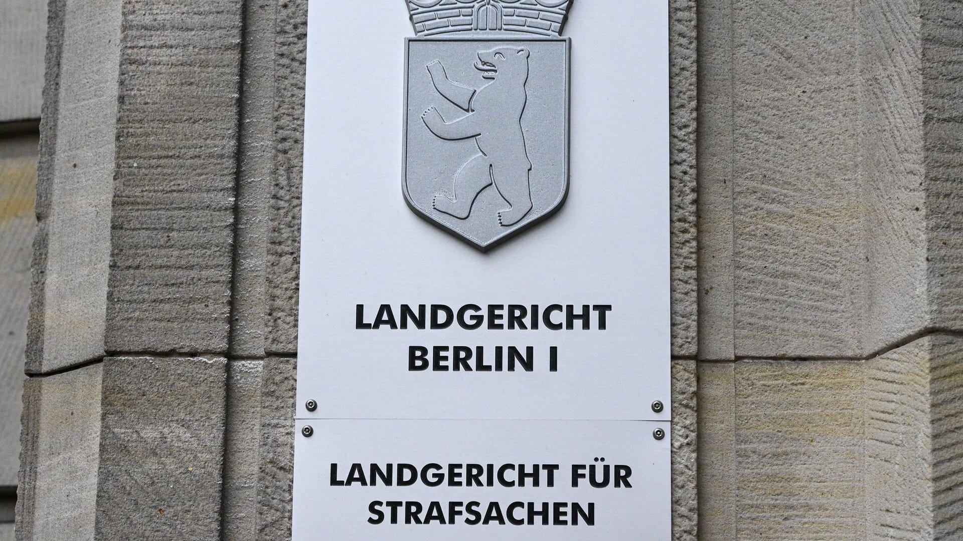 ARCHIV - 03.06.2024, Berlin: Ein Schild weist auf das Landgericht Berlin an der Fassade zum Kriminalgericht Moabit in der Turmstraße hin. (zu dpa: «Polizisten wegen ungerechtfertigter Kontrolle verurteilt») Foto: Jens Kalaene/dpa