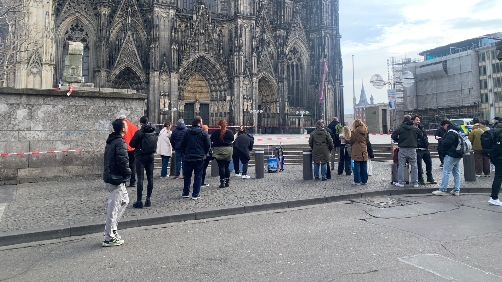 Polizeieinsatz: Die Absperrung an der Kölner Domplatte lockt zahlreiche Schaulustige an.