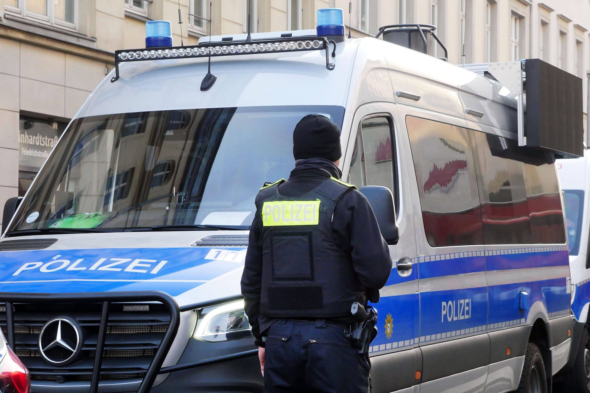 Polizist vor Polizeiauto (Symbolbild): Der Mann schubste einen Polizisten und Schlug ihm ins Gesicht.