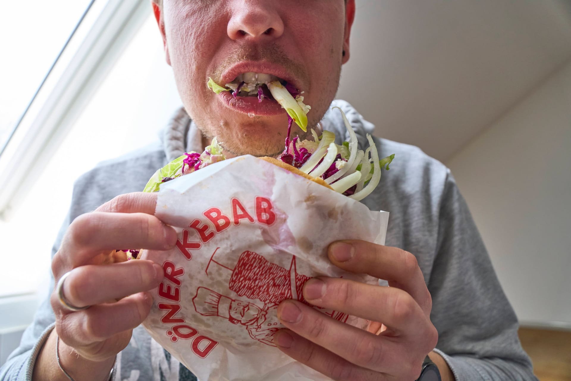 Ein Mann schlingt einen Döner runter: Bei Heißhungerattacken kann schnell ein unangenehmes Völlegefühl entstehen.