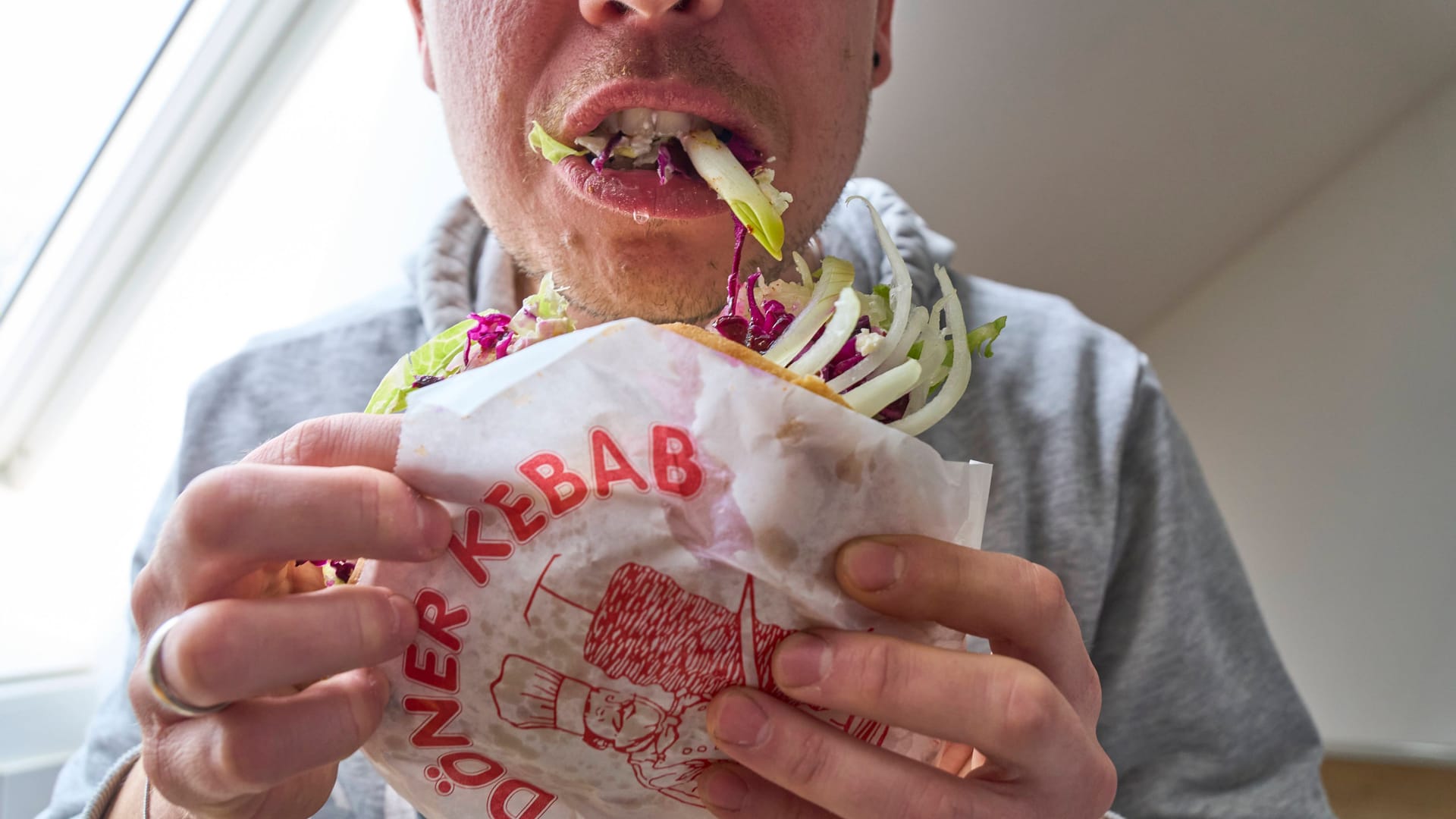 Ein Mann schlingt einen Döner runter: Bei Heißhungerattacken kann schnell ein unangenehmes Völlegefühl entstehen.