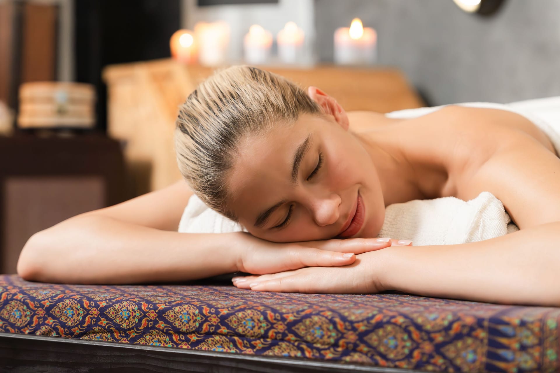 Beautiful caucasian woman lie on spa bed in front of sauna cabinet. Tranquility.